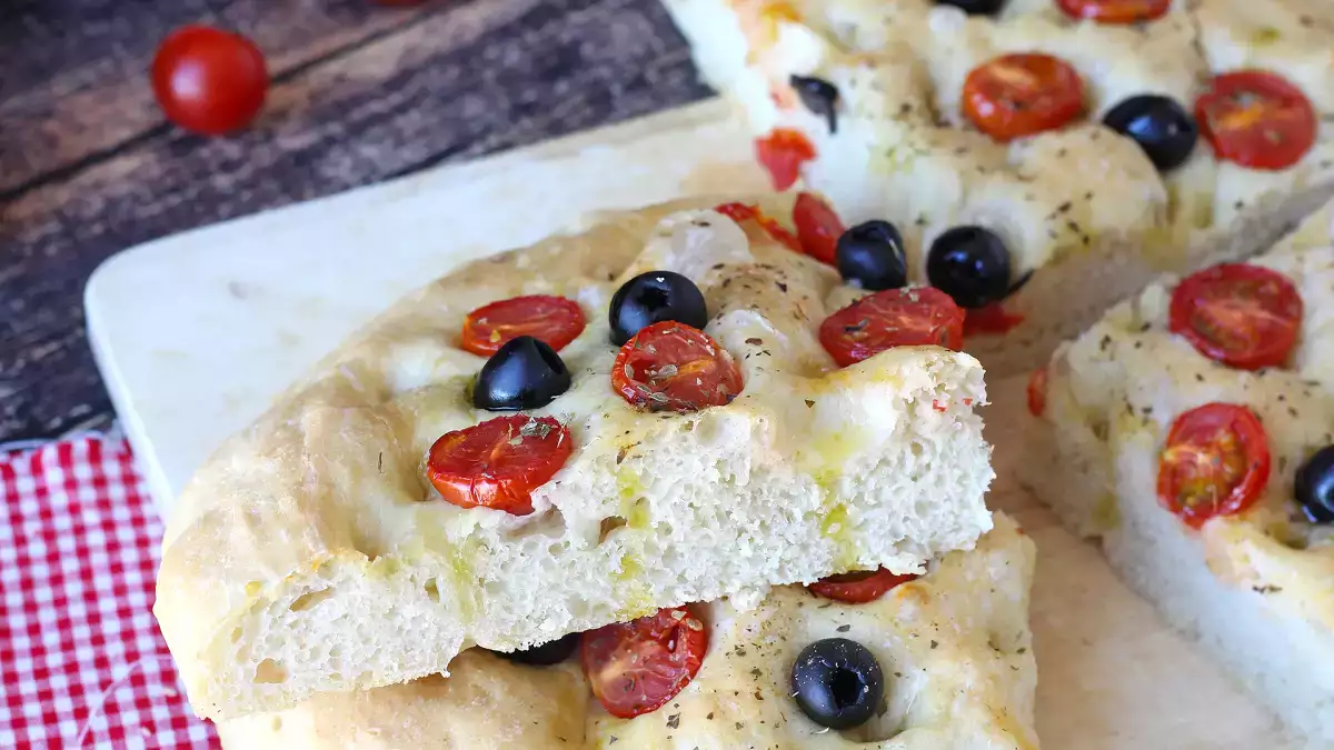 Focaccia tebal dengan tomat ceri dan zaitun ini sudah memikat sejak aromanya tercium: resep yang wajib dicoba