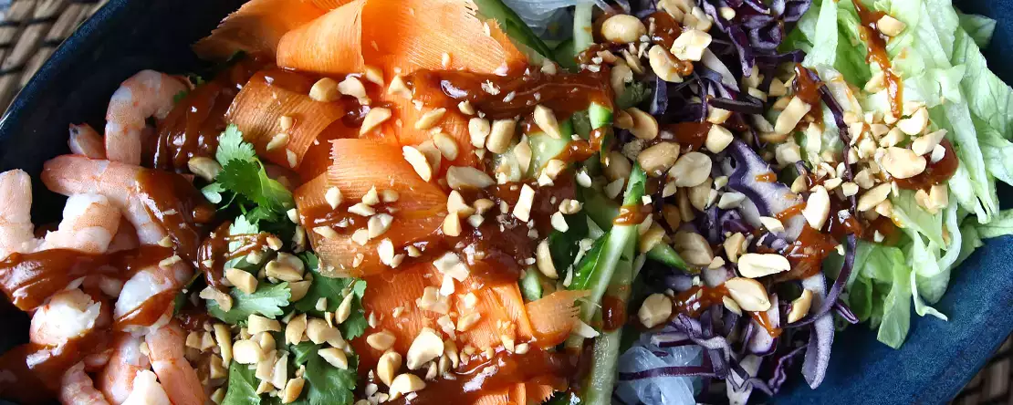 Salad warna-warni dengan bihun dan udang serta saus kacang pedas