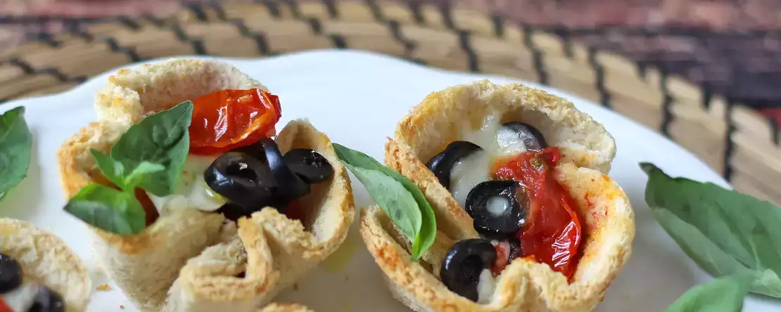 Keranjang roti dengan mozzarella, tomat ceri, dan zaitun hitam