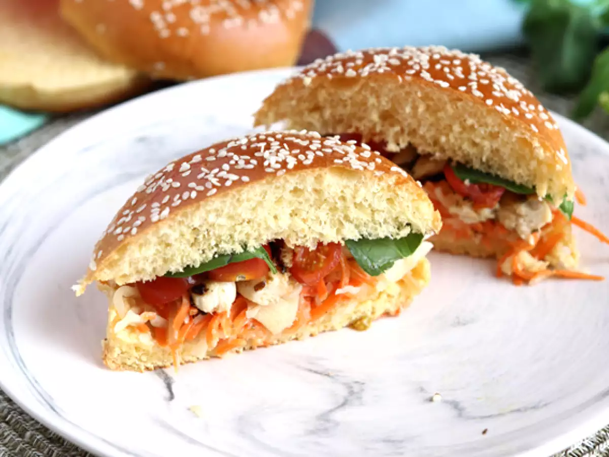 Sandwich ayam yang diasinkan dengan selada, tomat, dan kemangi