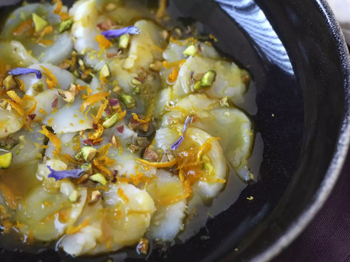 Scallop carpaccio dengan citrus vinaigrette dan pistachio, hidangan pembuka yang elegan dan mudah disiapkan.