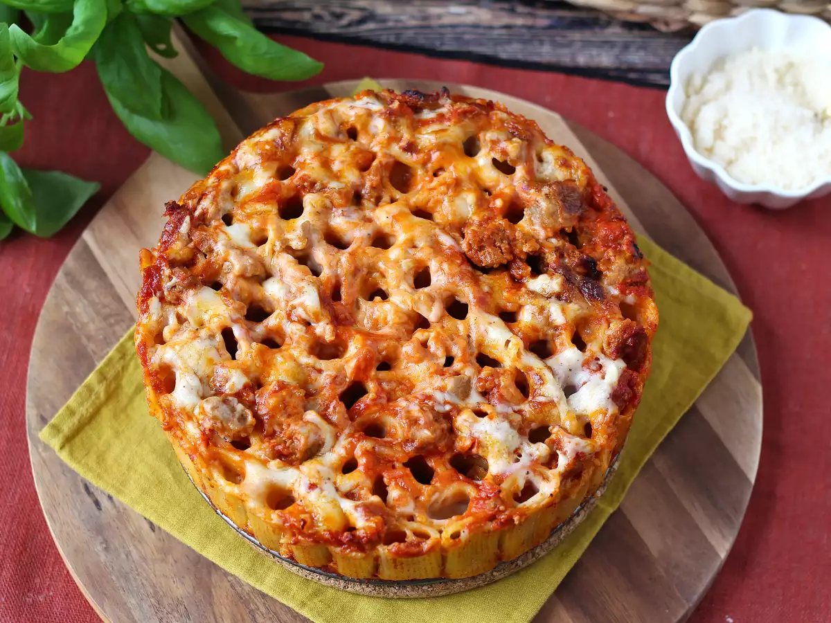 Timballo rigatoni panggang dengan sosis, saus bechamel, dan mozzarella